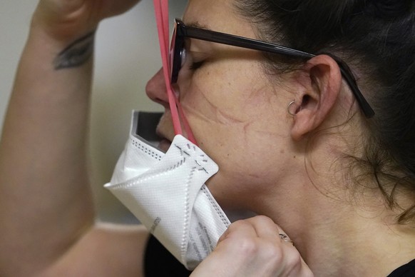 Registered nurse Jessalynn Dest pulls on a new N95 mask as indentations remain from another she had just removed after leaving a COVID-19 patient room in the acute care unit of Harborview Medical Cent ...