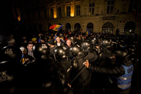 Riot police push supporters of Calin Georgescu after Romania&#039;s electoral body rejected his candidacy in the presidential election rerun in Bucharest, Romania,Sunday, March 9, 2025. (AP Photo/Andr ...