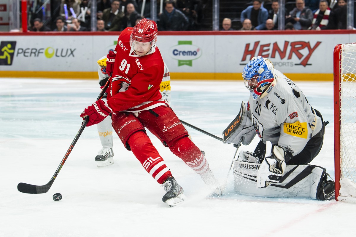 L'attaquant lausannois Joel Vermin, gauche, lutte pour le puck avec le gardien Fribourgeois Reto Berra, droite, lors de la rencontre du championnat suisse de hockey sur glace de National League e ...