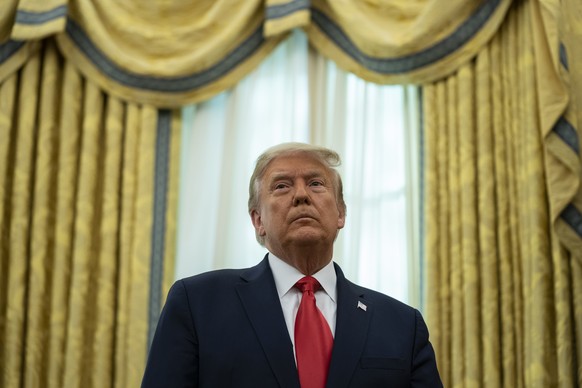 President Donald Trump listens during a ceremony to present the Presidential Medal of Freedom to former football coach Lou Holtz, in the Oval Office of the White House, Thursday, Dec. 3, 2020, in Wash ...