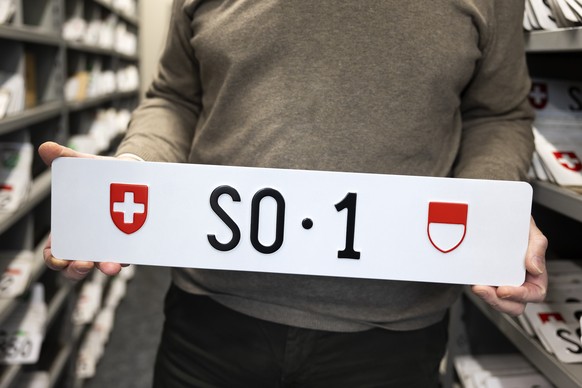 Ein Mitarbeiter der Motorfahrzeugkontrolle des Kantons Solothurn zeigt das Nummernschild SO 1, welches in einer Auktion zur Versteigerung ausgeschrieben ist, am Freitag, 5. Dezember 2025 in Bellach be ...