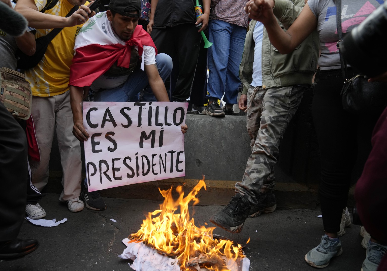 Supporters of ousted President Pedro Castillo burn a poster of newly-named President Dina Boluarte during a protest march in Lima, Peru, Friday, Dec. 9, 2022. Peru&#039;s Congress voted to remove Pres ...