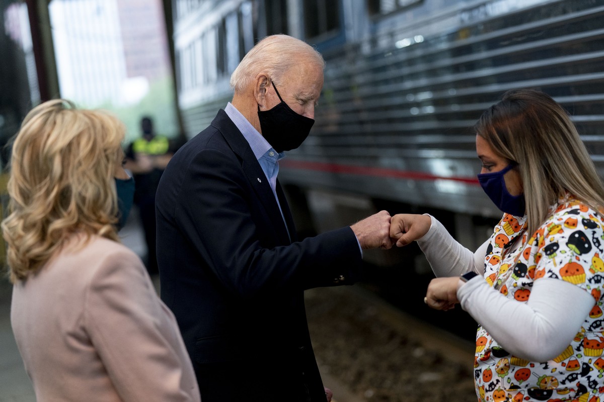 Democratic presidential candidate former Vice President Joe Biden, accompanied by his wife Jill Biden, left, fist bumps a supporter before boarding his train at Amtrak's Pittsburgh Train Station, ...