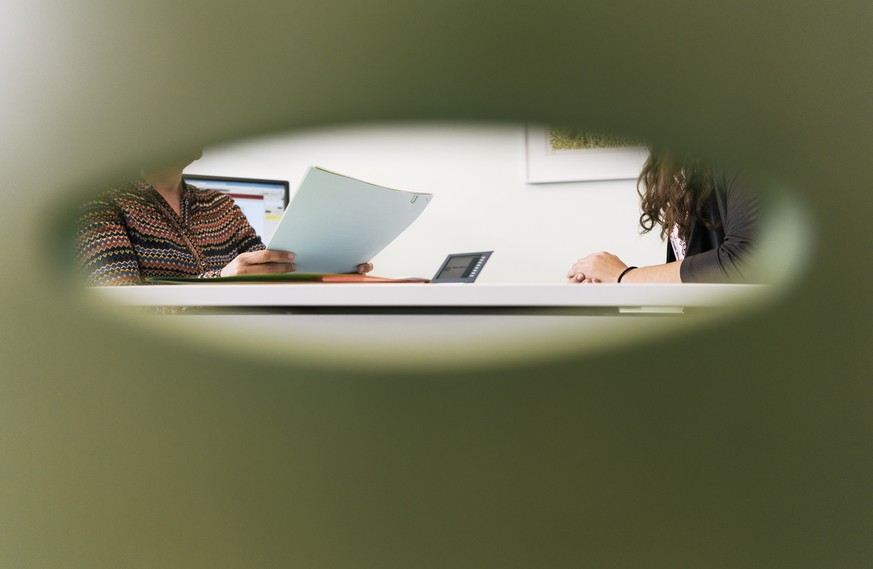 ARCHIVBILD ZU DEN ZAHLEN ZUR SOZIALHILFE 2016 --- A consultation meeting photographed through the back of a chair in an office of the social center Albisriederhaus on Albisriederstrasse in Zurich, Swi ...