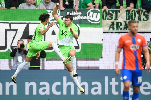 4 May 2024, Lower Saxony, Wolfsburg: Football: Bundesliga, Wolfsburg - Darmstadt 98, Round 32, Volkswagen Arena.  Wolfsburg player Jonas Wind celebrates after his goal with Wolfsburg player Kevin Paredes (left).  ...