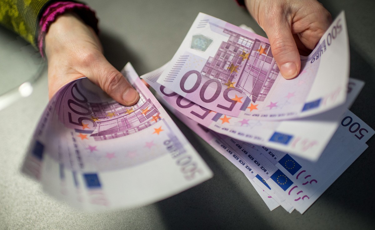 epa05141531 A bank employee holds 5,000 euros in 500-euro notes at a Sparkasse bank in Munich, Germany, 3 February 2016. Germany is considering imposing an upper limit on payments in cash as part of i ...