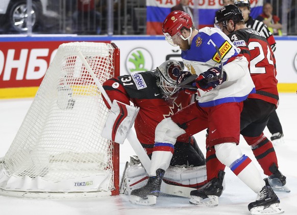 Canada&#039;s Calvin Pickard, left, blocks a shot by Russia&#039;s Ivan Telegin, second from right, at the Ice Hockey World Championships semifinal match between Canada and Russia in the LANXESS arena ...