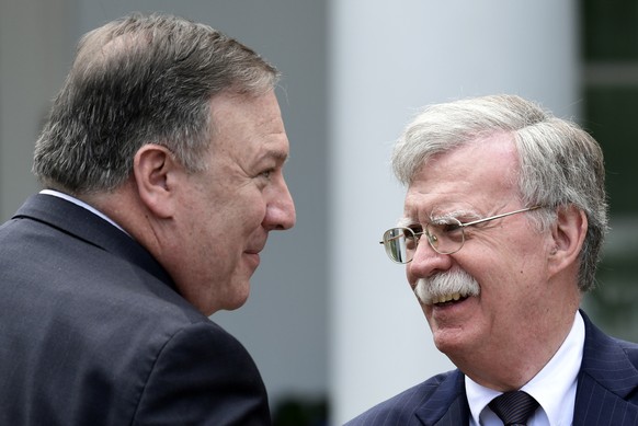 Secretary of State Mike Pompeo, left, and national security adviser John Bolton, right, talk before the start of a news conference with President Donald Trump and Japanese Prime Minister Shinzo Abe in ...