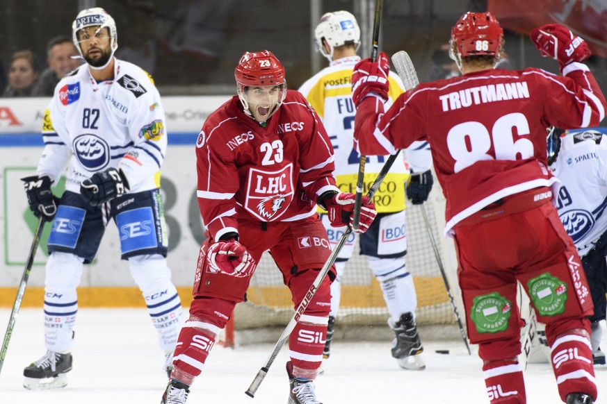 Le defenseur lausannois Dario Trutmann, droite, et lÕattaquant lausannois Alain Mieville, centre, celebrent le 1er but devant le defenseur tessinois Michael Ngoy, gauche, lors du match du championnat  ...