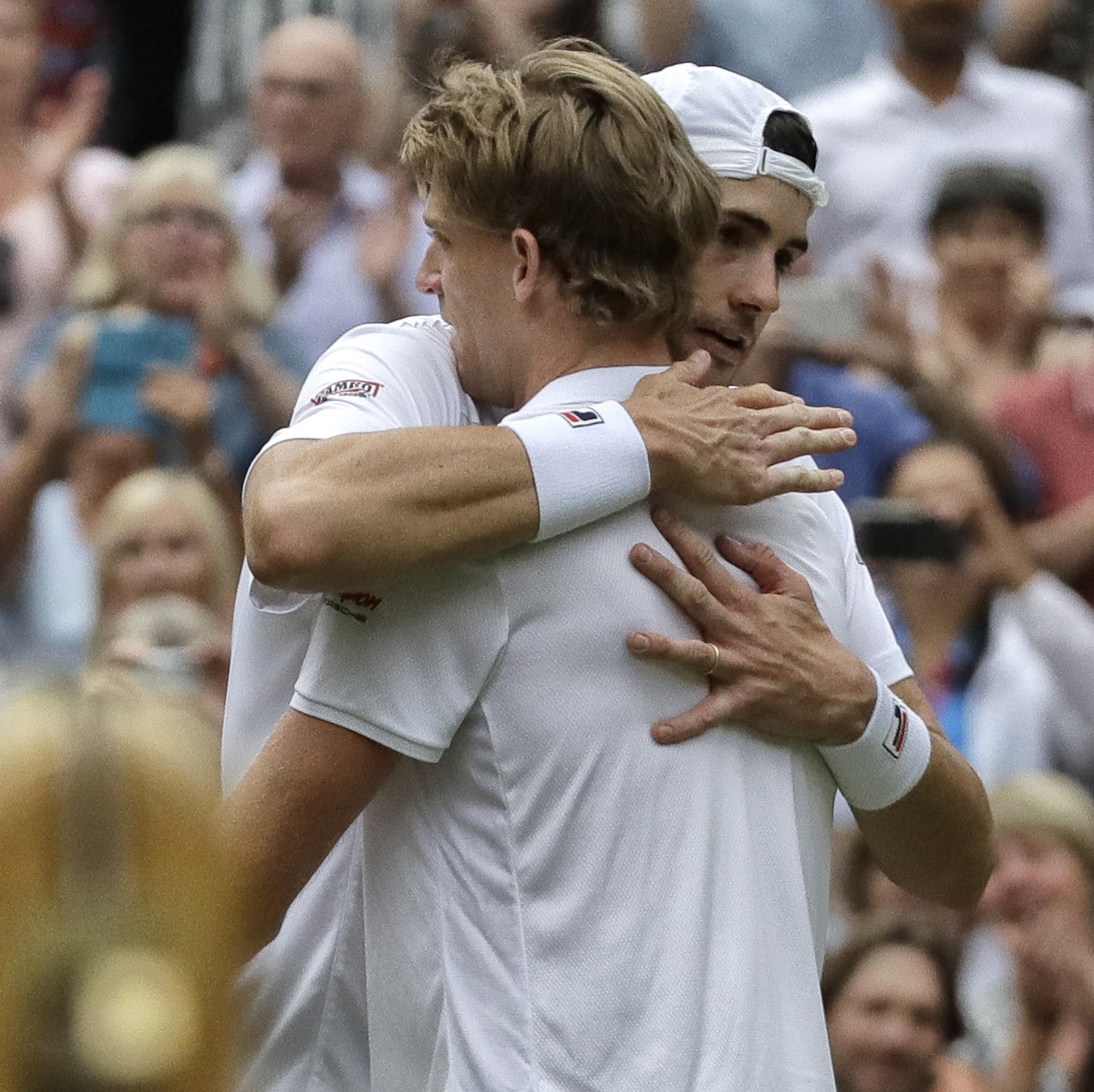 South Africa's Kevin Anderson hugs John Isner of the United States, right, after defeating him in their men's singles semifinals match at the Wimbledon Tennis Championships, in London, Frida ...