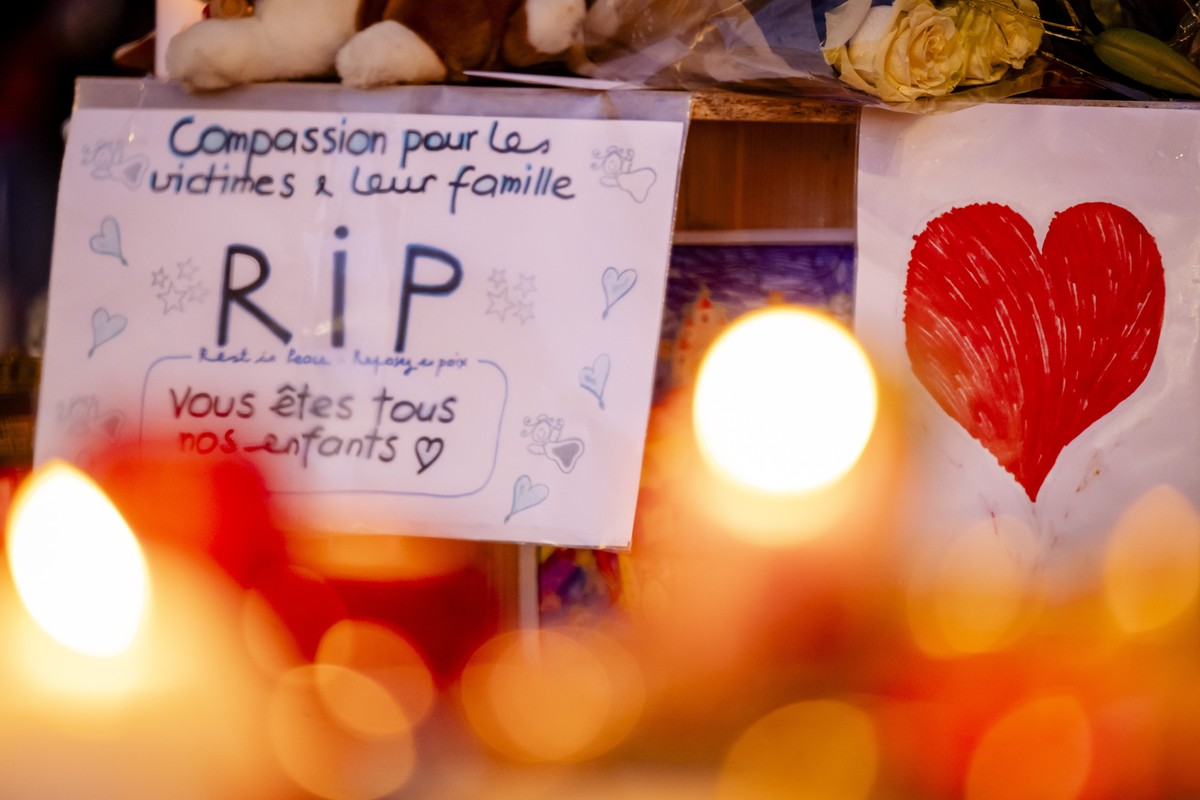 epa12626285 Flowers and candles are pictured in tribute to the victims after the fire at the 'Le Constellation' bar and lounge, in Crans-Montana, Switzerland, 04 January 2026. At least 40 pe ...