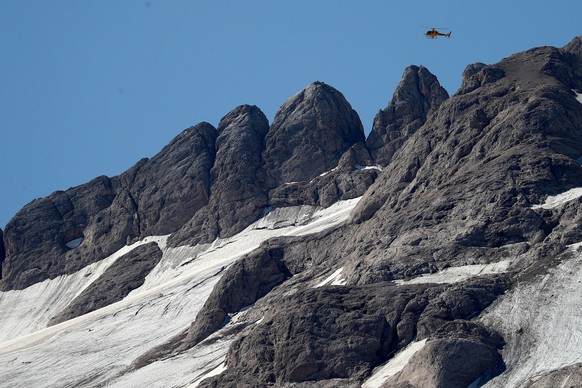 epa10051090 A helicopter flies over the Marmolada Mountain in the aftermath of an avalanche, in Canazei, Italy, 04 July 2022. At least six people were killed and dozens were still missing on 04 July,  ...