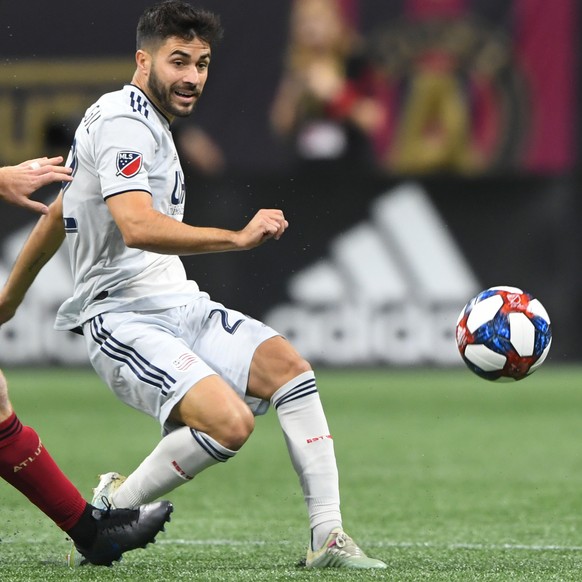 Atlanta United forward Hector Villalba, left, defends a kick by New England Revolution midfielder Carles Gil during the first half of an MLS Cup playoff soccer game Saturday, Oct. 19, 2019, in Atlanta ...