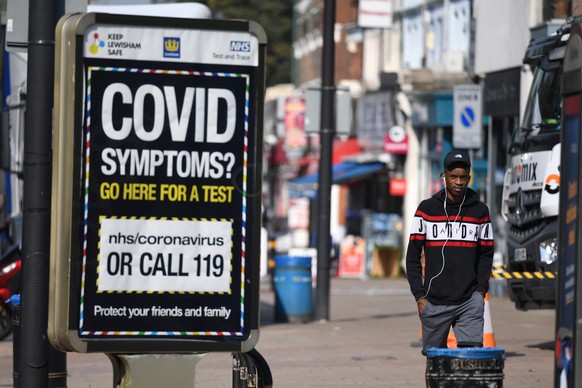 epa08670849 Pedestrians walk past a sign displaying a Covid helpline in London, Britain, 15 September 2020. In order to curb the rise in coronavirus cases in the UK, it is now illegal for groups of more than six to meet up. The 'rule of six' have been implemented in the latest push to curb the recent surge in coronavirus infections in the United Kingdom.  EPA/FACUNDO ARRIZABALAGA
