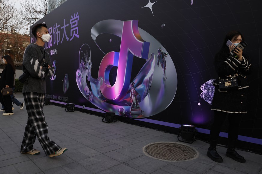 A woman speaks on her phone near the logo for Douyin in Beijing on Wednesday, March 31, 2021. China&#039;s internet watchdog said Friday, May 21, 2021 it had found Bytedance&#039;s Douyin, Microsoft B ...