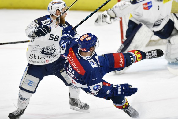 Der Zuercher Mike Kuenzle, limks, gegen den Tessiner Jesse Zgraggen, links, beim Eishockeyspiel der National League ZSC Lions gegen den HC Ambri-Piotta im Hallenstadion in Zuerich am Samstag, 13. Janu ...