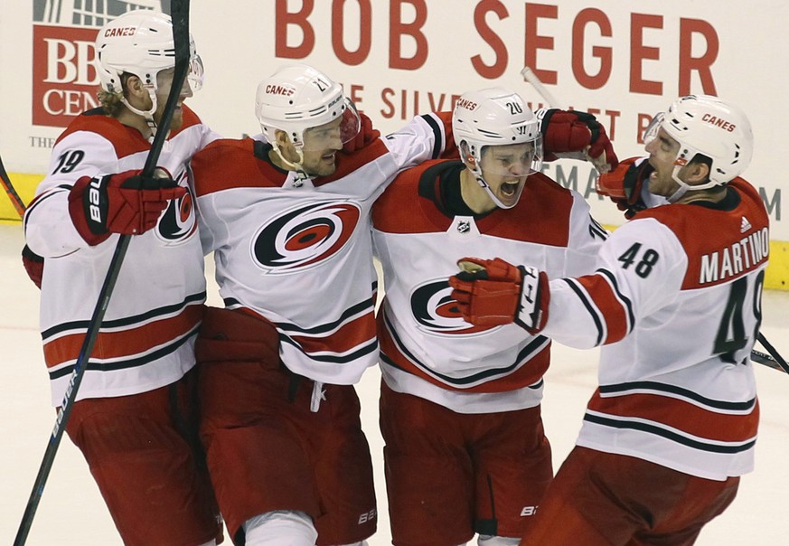 Carolina Hurricanes&#039; Sebastian Aho, second from right, celebrates with teammates Dougie Hamilton (19), Nino Niederreiter, second from left, and Jordan Martinook (48) after scoring the winning goa ...