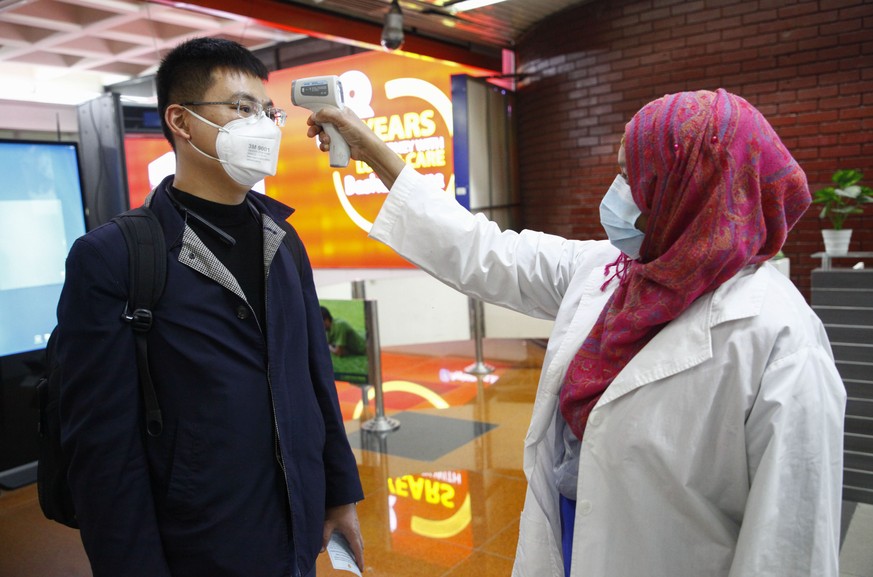 A passenger from Beijing is screened as part of measures to prevent coronavirus infection at Hazrat Shahjalal International airport in Dhaka, Bangladesh, Wednesday, Jan.29, 2020. (AP Photo/Al-emrun Ga ...