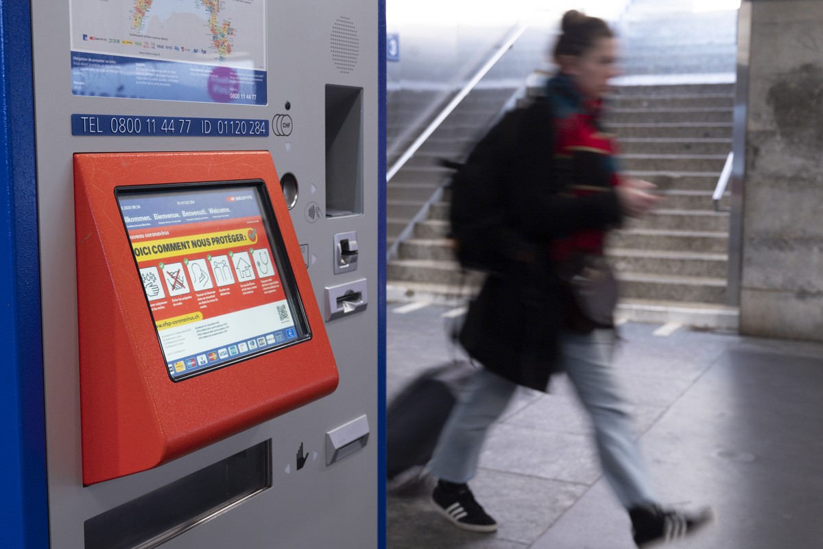 Une personne marche a cote d'un distributeur automatique de billet a la Gare CFF de Lausanne lors de la pandemie du virus Coronavirus, (Covid-19) ce lundi 16 mars 2020 a Lausanne. (KEYSTONE/Leand ...