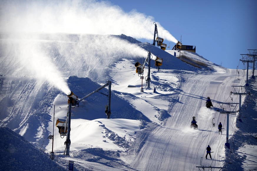 Snowmaking machines spray artificial snow on a ski slope during the FIS Ski Cross World Cup, a test event for the 2022 Winter Olympics, at the Genting Resort Secret Garden in Zhangjiakou in northern C ...