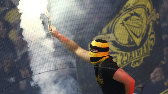 Ein YB Fan zuendet Pyro an beim Fussball Meisterschaftsspiel der Super League zwischen dem BSC Young Boys und dem FC Zuerich am Dienstag, 1. Mai 2012, im Stade de Suisse Wankdorf in Bern. (KEYSTONE/Pe ...