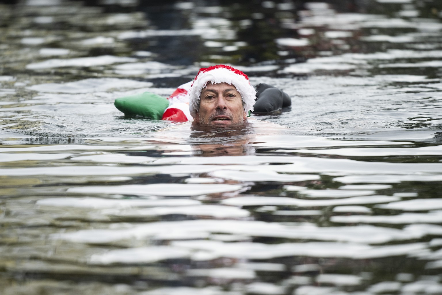 epa11060672 A man takes part in the Befana Swimming in Brissago, Switzerland, 06 January 2024. During the traditional &#039;Nodada de la Befana&#039;, the Lago Maggiore in the port of Brissago is trav ...