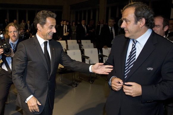 French President Nicolas Sarkozy, left, cheers next to UEFA President Michel Platini, right, after the host of the UEFA Euro 2016 European soccer championships annoucement, at the Espace Hippomene, in ...