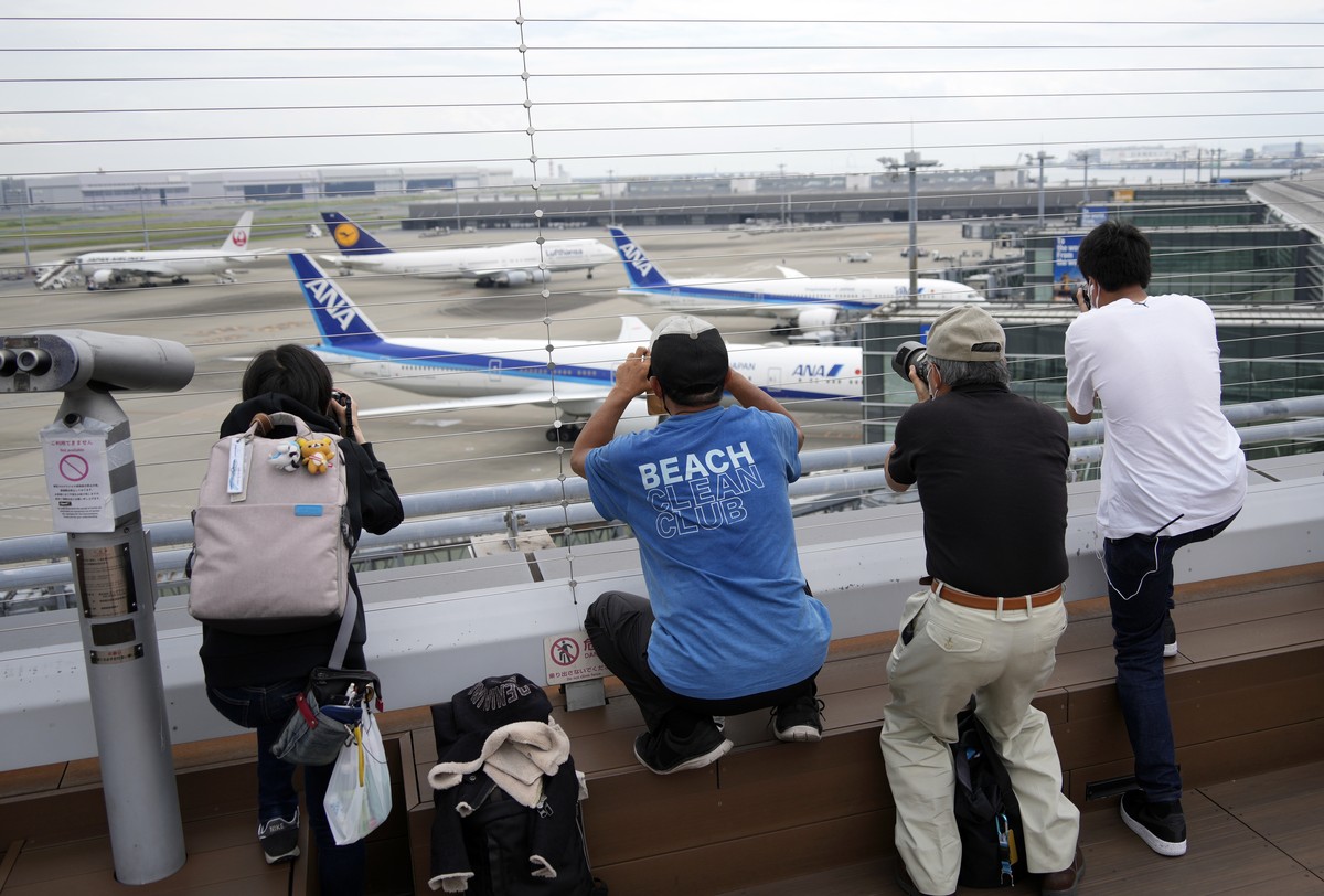 epa10005288 People take pictures of a Lufthansa aircraft after landing at Haneda airport's international flights terminal in Tokyo, Japan, 10 June 2022. Japan started to welcome foreign tourists  ...