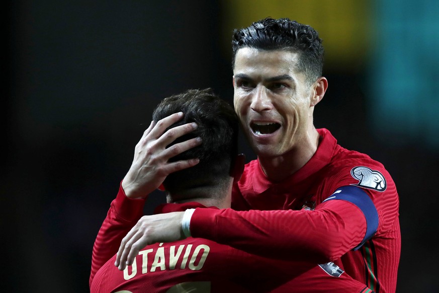 epa09847457 Portugal&#039;s Otavio (L) celebrates with his team mate Cristiano Ronaldo (R) after scoring during the FIFA World Cup Qatar 2022 play-off qualifying soccer match between Portugal and Turk ...