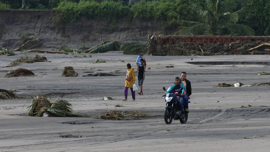 epa06403706 Filipino villagers along a river after a flashflood in the town of Salvador, Lanao del Norte province, Philippines, 23 December 2017. According to news reports, Tropical storm Tembin broug ...