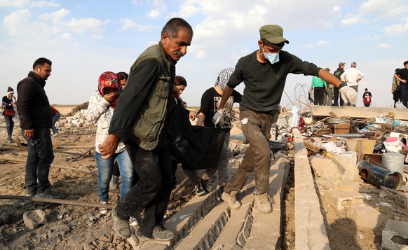 epa07934980 American volunteers Free Ranger team and Syrian Kurdish men carry the body of a victim who was killed by Turkish bombing at Ras al-Ain town, northeastern Syria, 18 October 2019 (issued 19  ...