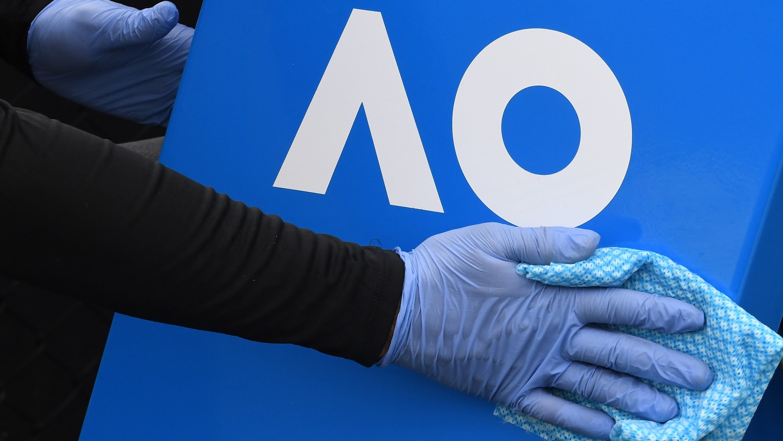 epa08986064 A cleaner wipes down equipment at the deserted Melbourne Park, the venue for the Australian Open and its lead in events in Melbourne, Australia, 04 February 2021. Australian Open preparati ...