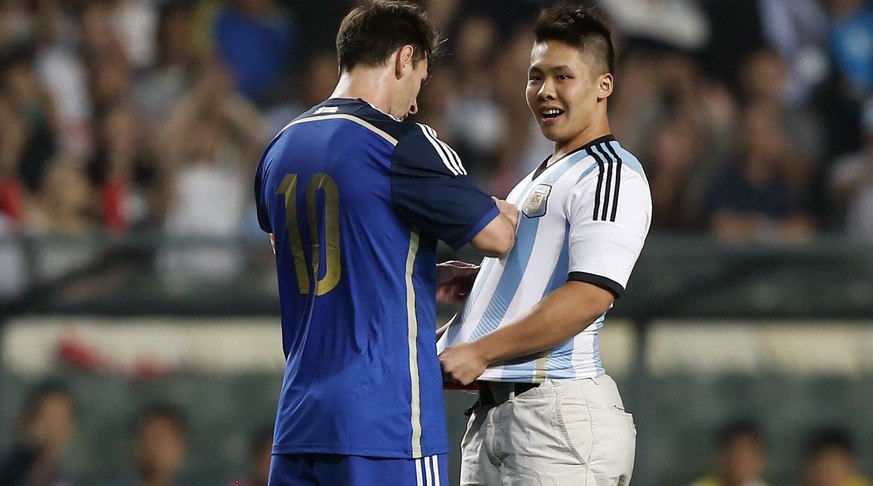 Sicher ist sicher: Dieser Flitzer holt sich die Unterschrift von Lionel Messi noch während dem Spiel.