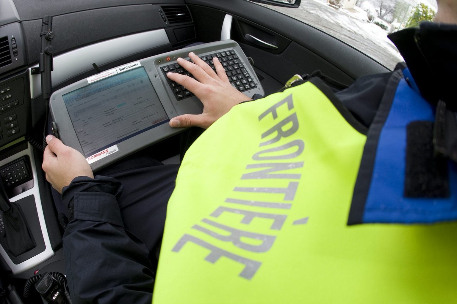 Swiss border guards check the identity of a driver on the Schengen Information System, also called SIS, at the Swiss-French border of Croix-de-Ronzon, in Geneva, Switzerland, Thursday, December 11, 20 ...