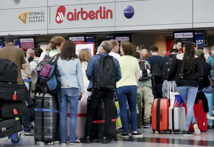 Travellers whose flights have been cancelled by Air Berlin wait in front of the Air Berlin desk at the Duesseldorf Airport, Germany, Tuesday, Sept. 12, 2017 when the airline had to cancel dozens of fl ...