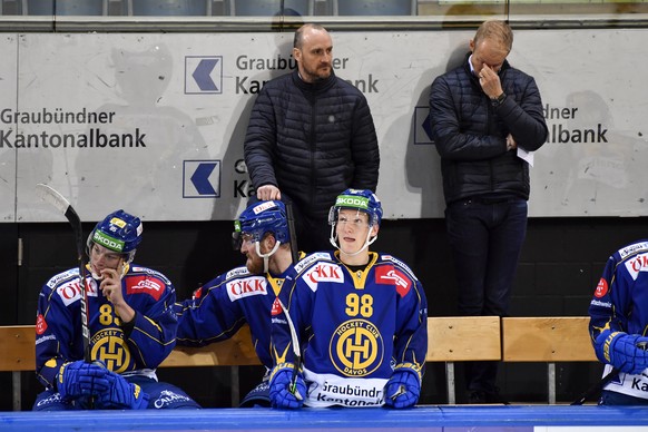 Davos Spieler Florian Ritzmann und Benjamin Baumgartner auf der Spielerbank. Hinter ihnen Trainer Christian Wohlwend (L) und Assistenztrainer Johan Lundskog, im ersten Eishockey-Pre-Playoff Qualifikat ...