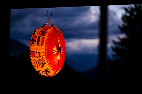 Un lampion pour la Fete national suisse est accroche sur le balcon d&#039;un chalet le samedi 12 juillet 2025 a Muehlebach dans la valle de Conches. (KEYSTONE/Jean-Christophe Bott)
