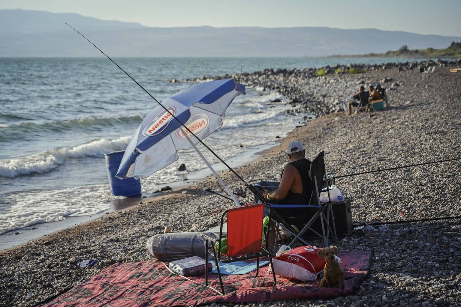 Israel Ein Gev Beach Crowded Amid Truce A man fishes at Halukim Beach of the Sea of Galilee on the Shabbat s eve, near Kibbutz Ein Gev, June 27, 2025. Israeli Arabs and Jews enjoy their leisure time o ...