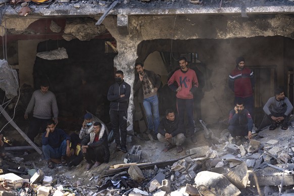 Palestinians search for bodies and survivors in the rubble of a residential building destroyed in an Israeli airstrike, in Rafah, southern Gaza Strip, Tuesday, Dec. 19, 2023. (AP Photo/Fatima Shbair)