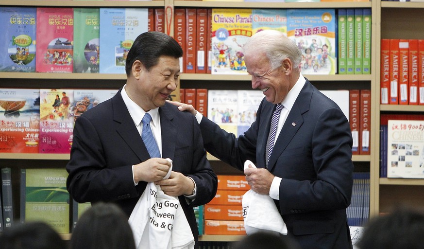 FILE - Chinese Vice President Xi Jinping and Vice President Joe Biden hold T-shirts students gave them at the International Studies Learning Center in South Gate, Calif., Feb. 17, 2012. As President J ...