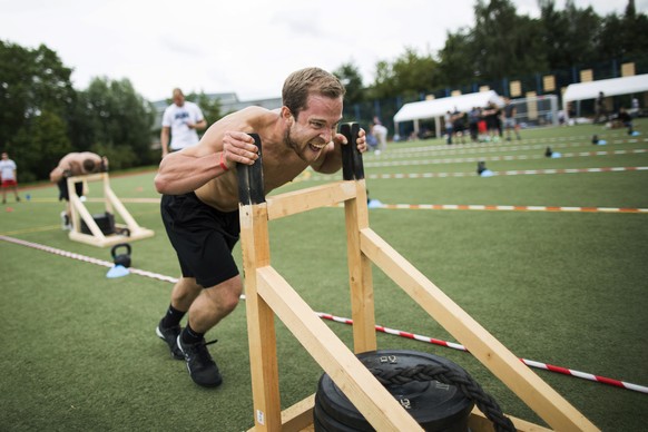 In this Aug. 5, 2017 photo Pit Ressler of Kiel&#039;s Foerde CrossFit pushes a sled during his third workout session at the fourth edition of the &quot;Battle of Rostock&quot;, a CrossFit competition  ...