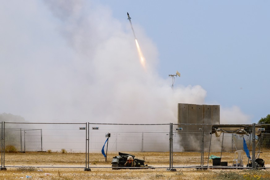 Ein israelischer Soldat geht in Deckung während das Raketenabwehrsystem Iron Dome eine Abfangrakete abschiesst.