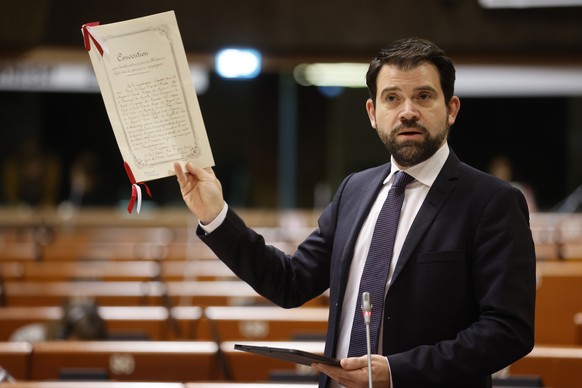 Swiss speaker Damien Cottier holds the Geneva Convention on international legal standards for humanitarian treatment in war during a session at the Council of Europe Parliamentary Assembly (PACE) in S ...