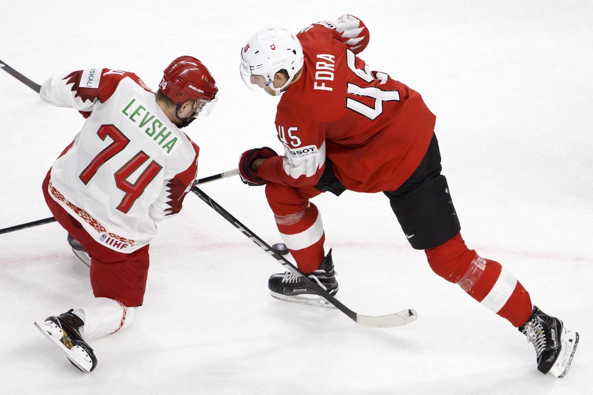 Belarus' forward Artyom Levsha, left, vies for the puck with Switzerland's defender Michael Fora, right, during the IIHF 2018 World Championship preliminary round game between Switzerland an ...