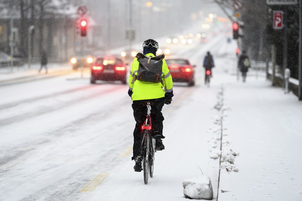 Eine Person faehrt auf dem Velo im Schnee, am Freitag, 10. Dezember 2021 in Bern. (KEYSTONE/Anthony Anex)