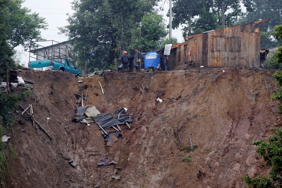 Residents stand outside their damaged houses after a mudslide following heavy showers caused by the passing of Tropical Storm Earl, in the town of Huauchinango, in Puebla state, Mexico, August 7, 2016 ...