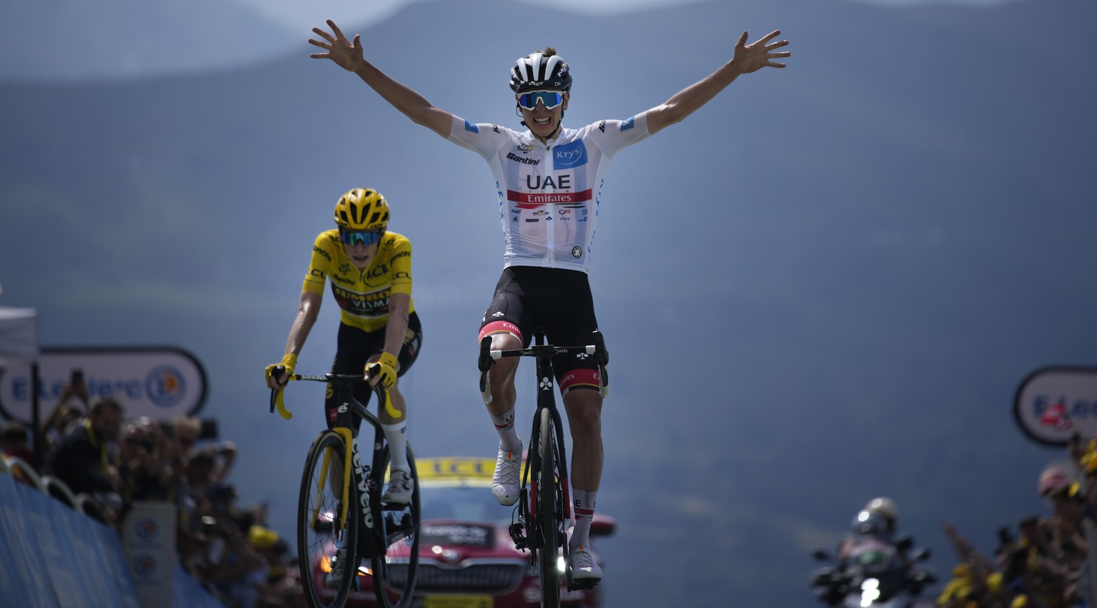Stage winner Slovenia&#039;s Tadej Pogacar, wearing the best young rider&#039;s white jersey, celebrates as he crosses the finish line ahead of Denmark&#039;s Jonas Vingegaard, wearing the overall lea ...