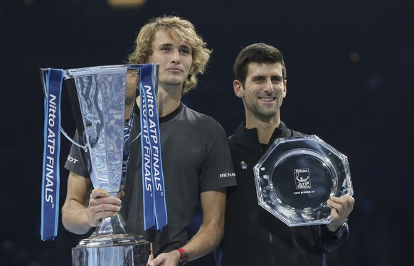 Alexander Zverev of Germany holds his winner trophy and Novak Djokovic of Serbia holds his runner-up trophy after their ATP World Tour Finals singles final tennis match at the O2 Arena in London, Sund ...