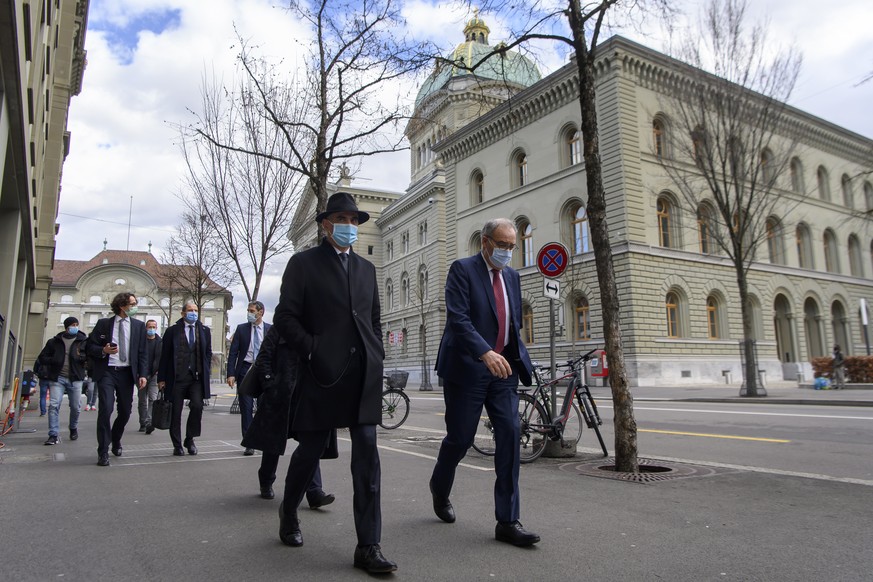 Bundesrat Alain Berset, links, und Bundesratspraesident Guy Parmelin, rechts, auf dem Weg zur Medienkonferenz zu den neusten Massnahmen zur Bewaeltigung der Coronavirus-Pandemie im Anschluss an die Bu ...