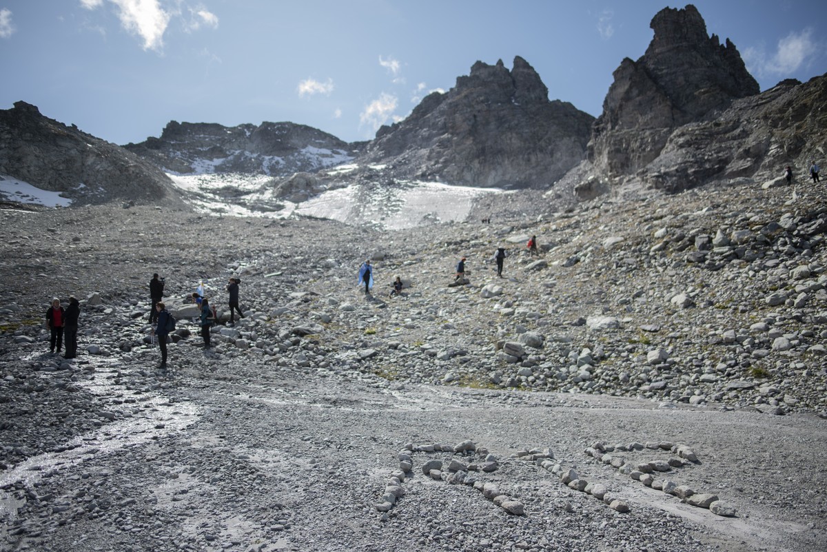 The letters 'RIP' (rest in peace) are written with stones during a commemoration in front of the 'dying' glacier of Pizol mountain in Wangs, Switzerland, Sunday, Sept. 22, 2019. Va ...